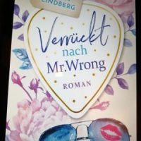 Buchcover "Verrückt nach Mr. Wrong" von Karin Lindberg. Pastellfarbenes Cover mit Sonnenbrille, Blumen und dem Titel in einem Herzen.
