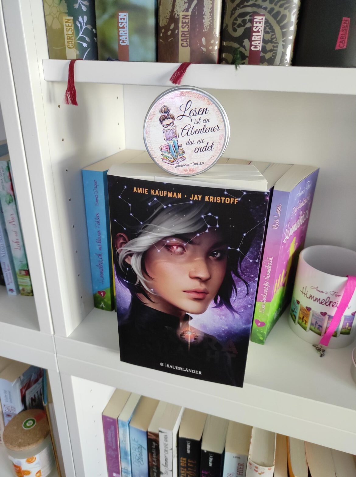 Buch mit Mädchenkop au dem Cover steht m Bücherregal